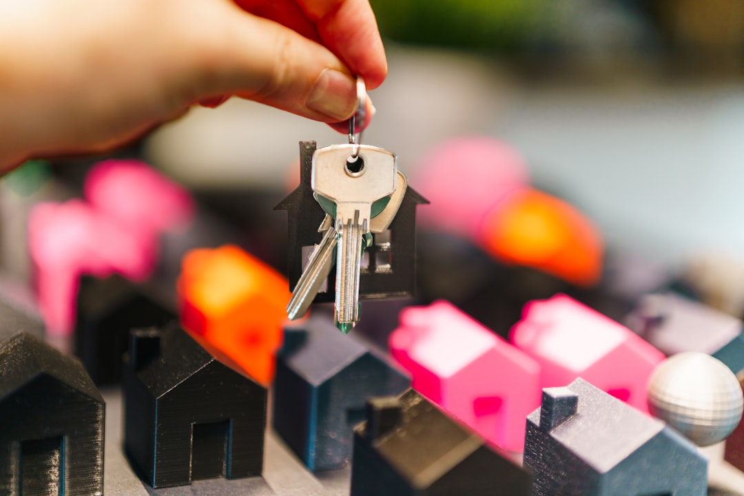 A smiling family stands proudly in front of a beautiful new suburban house, holding up a set of keys to celebrate their successful home purchase.