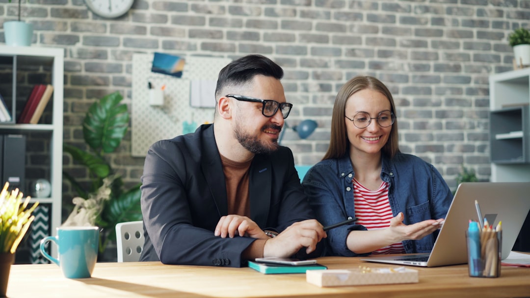 Couple sits at a bright kitchen table, looking thoughtfully at real estate documents and a calculator, questioning the hig...