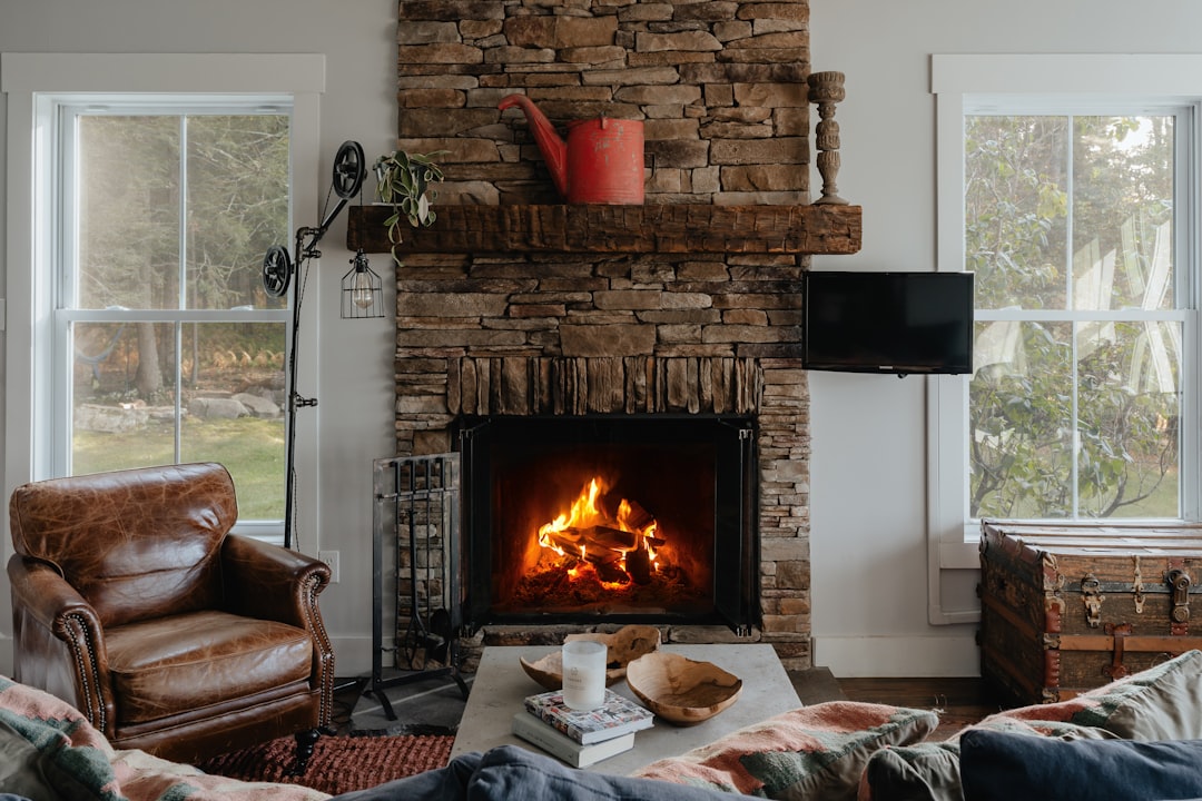An elegant living room staged with leather armchairs by a cozy fireplace, creating a sophisticated entertainment space that appeals to discerning homebuyers.