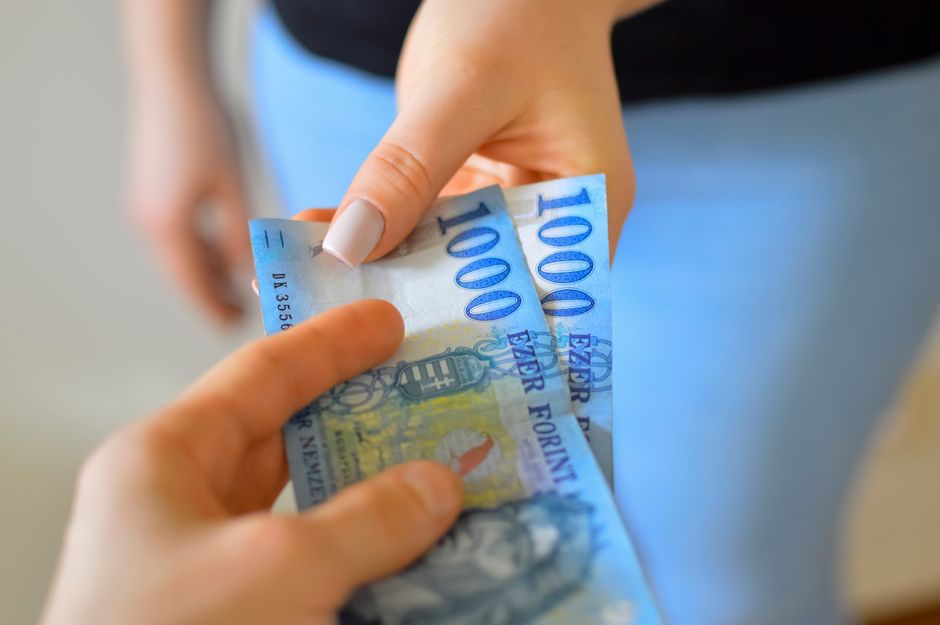 A cinematic close-up shot focusing on two sets of hands exchanging a house key for a stack of cash, symbolizing the high-stakes financial transaction of a real estate deal.