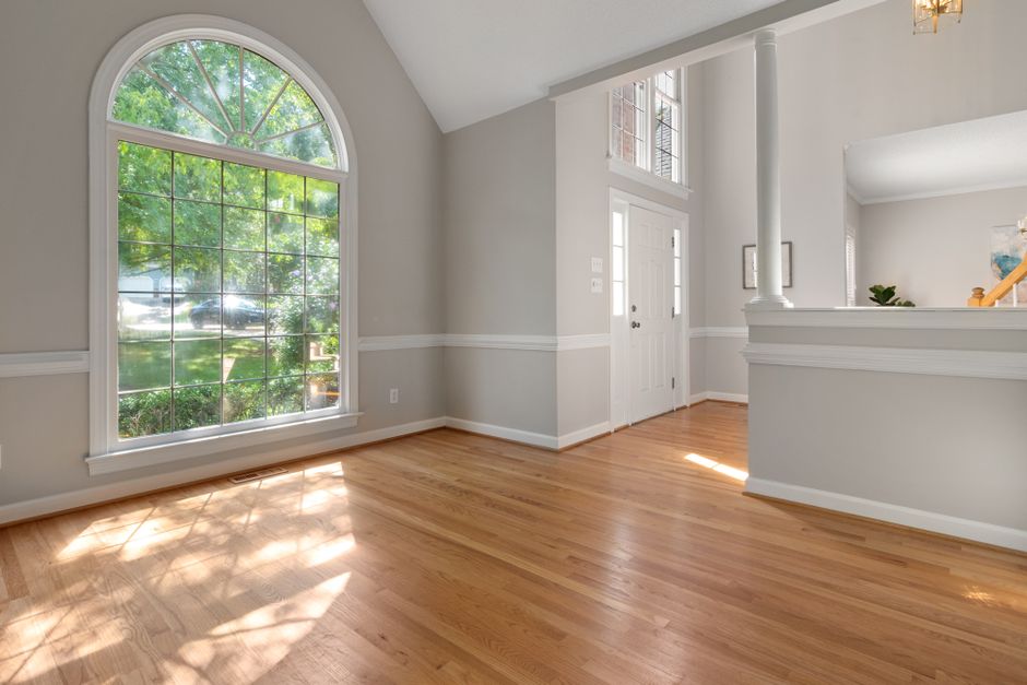 A bright and airy modern living room, professionally staged with neutral-toned furniture and tasteful decor to appeal to out-of-state home buyers online.